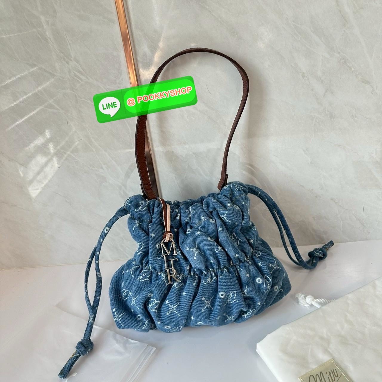Mitr scrunchy bag 🔖กระเป๋ายีนส์สุดน่ารักเนื้อนุ่มพิมพ์ลาย Monogram ของ Mitr จุของได้เยอะรูปทรงแบบรูดได้ น้ำหนักเบาสุดๆ สะพายเป็น Shoulder Bag หรือถอดสายและถือเป็น Clutch Bag ก็ได้ ดีเทล Charm ห้อยโลหะสีเงิน โดดเด่นสุดๆ