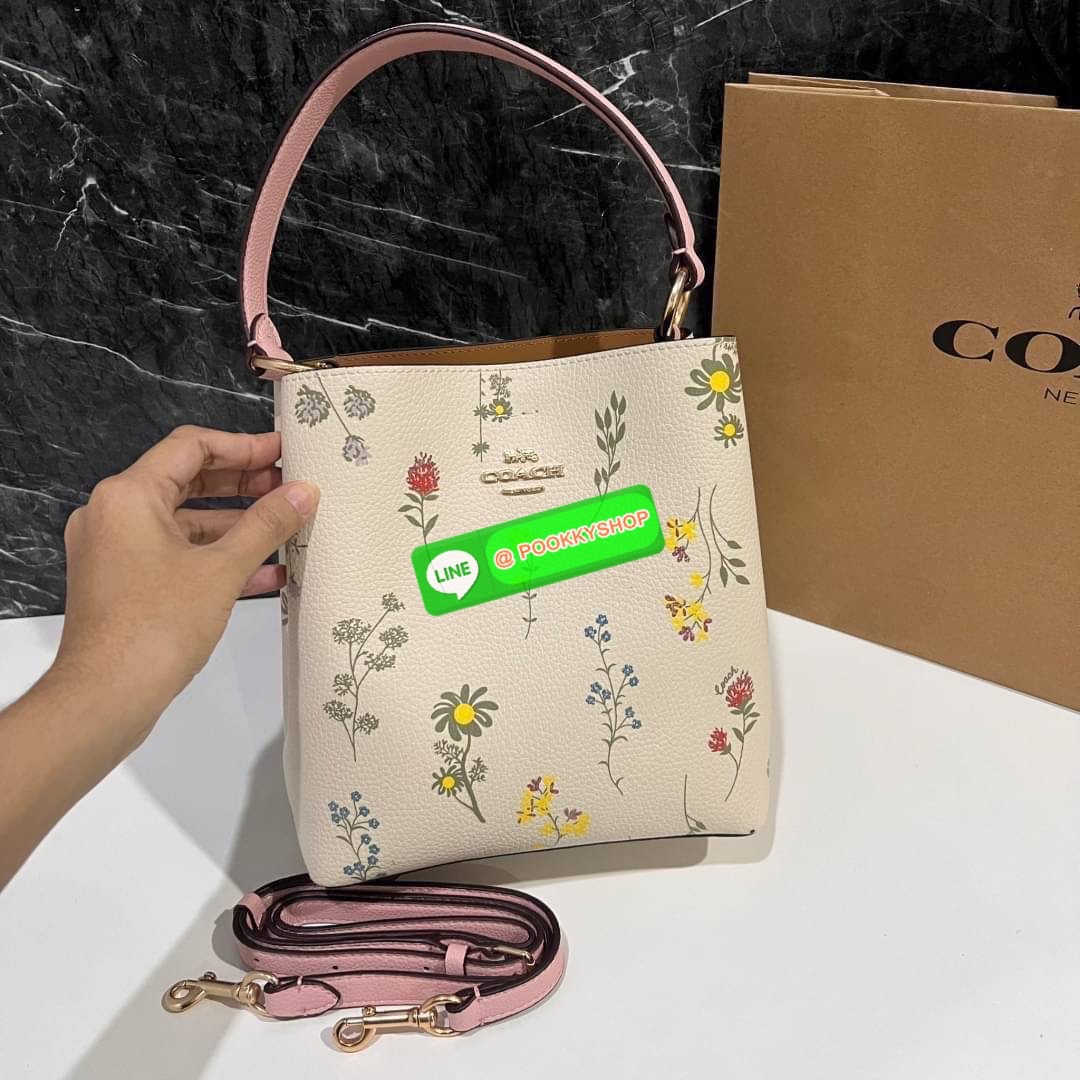 COACH C3598 SMALL TOWN BUCKET WITH SPACED WILDFLOWER PRINT มีความน่ารักละมุนมาก กระเป๋าทรงบัคเก็ต ดีไซน์ดอกไม้คละรอบใบ วัสดุหนังแท้ปากกระเป๋าเปิด-ปิดด้วยกระดุมแม่เหล็ก 2 มีหูจับในตัวและสายสะพายข้าง ภายในโล่งกว้าง มีช่องซิปแยกสัดส่วนตรงกลาง สายสะพายปรับระด