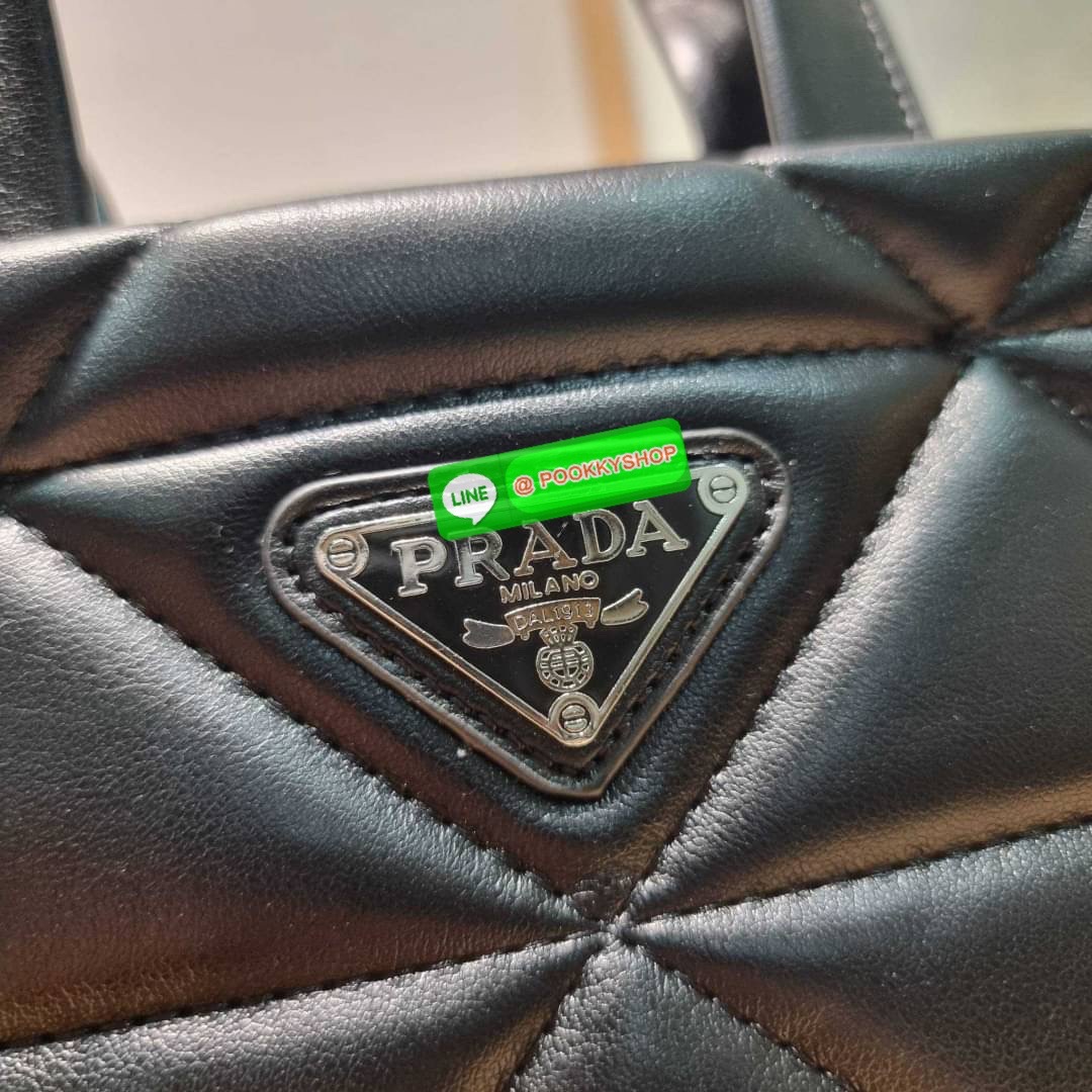 PRADA LEATHER PADDED BAG ใหม่ล่าสุด กับคอลเลคชั่นที่ทำออกมาตอบโจทย์ได้ทุกไลฟ์สไตล์ และเป็นยูนิเซ็กส์ กับกระเป๋าทรงโท้ท ขนาดกำลังดี วัสดุหนังแท้ ตัดเย็บเดินเส้นลายตาราง ปากกระเป๋ามีซิปเปิดปิด ภายในเป็นช่องโล่ง มีช่องแยกให้ มาพร้อมสะพายข้างและใบลูก ให้ได้สน