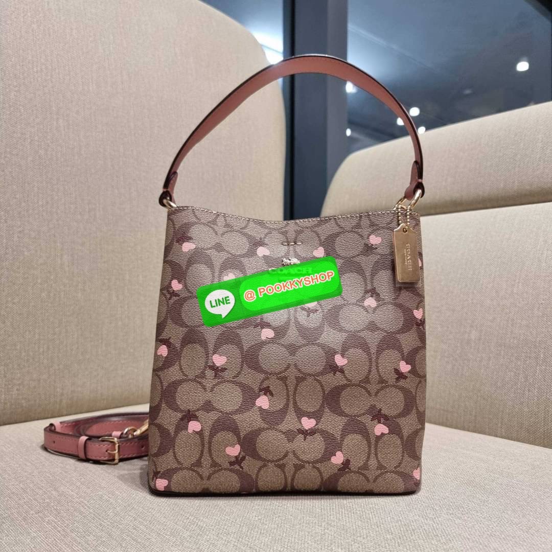 COACH C3238 SMALL TOWN BUCKET BAG IN SIGNATURE CANVAS WITH HEART FLORAL PRINT กระเป๋าบัคเก็ตน่ารักสดใส ลายพริ้นท์หัวใจเต็มใบ ดีไซน์ตัดกับสีกากีได้อย่างลงตัว วัสดุหนังแคนวาสเคลือบลาย ปากกระเป๋าเปิด-ปิดด้วยกระดุมแม่เหล็ก 2ฝั่ง มีหูจับในตัวและสายสะพายข้างมาใ