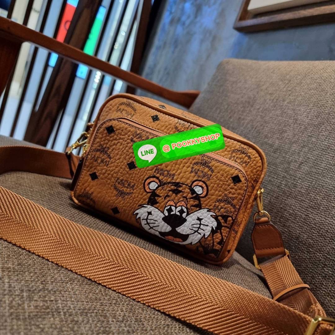 MCM KLASSIK CROSSBODY IN NEW YEAR TIGER VISETOS ใหม่ล่าสุด คอลเลคชั่นรับปีเสือ ของมันต้องมี กระเป๋าสะพายข้างทรงครอสบอดี้ โดดเด่นด้วยลายพริ้นท์น้องเสือคมสวย รุ่นนี้หนุ่มๆหรือสาวๆก็สะพายได้น้า ขนาดกำลังดี วัสดุหนังแคนวาสคุณภาพดี มีช่องหลัก 2 ช่อง เปิด-ปิดด้