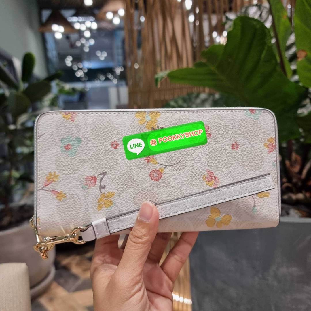 COACH C8695 LONG ZIP AROUND WALLET IN SIGNATURE CANVAS WITH MYSTICAL FLORAL PRINT พร้อมเสิร์ฟความหรู กับคอลใหม่ล่าสุด กระเป๋าสตางค์ใบยาวกึ่งคล้องมือ มาในดีไซน์ผู้ดี เรียบหรู ถือใช้แล้วขับผิวมาก ลวดลายดอกไม้คละเคล้าสวยงาม วัสดุหนังแคนวาสเคลือบลาย มาพร้อมสา
