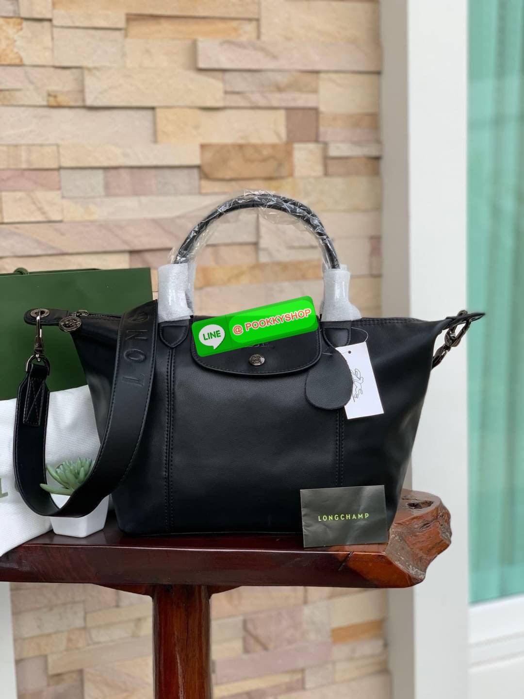 Longchamp LE PLIAGE CUIR TOP HANDLE BAG S เรียกว่าเป็นกระเป๋าอีกหนึ่งรุ่นที่ไม่ว่ายังไงก็ฮอตฮิตและติดเทรนด์ตลอดไม่เคยเปลี่ยนกับ ทรง Le Pliage Cuir หนึ่งในตระกูลกระเป๋าสุดไอคอนิกจากแบรนด์ เมื่อรุ่น Le Pliage Cuir ในรูปแบบของหนังแกะ Metis ได้ถือกำเนิดขึ้นใน