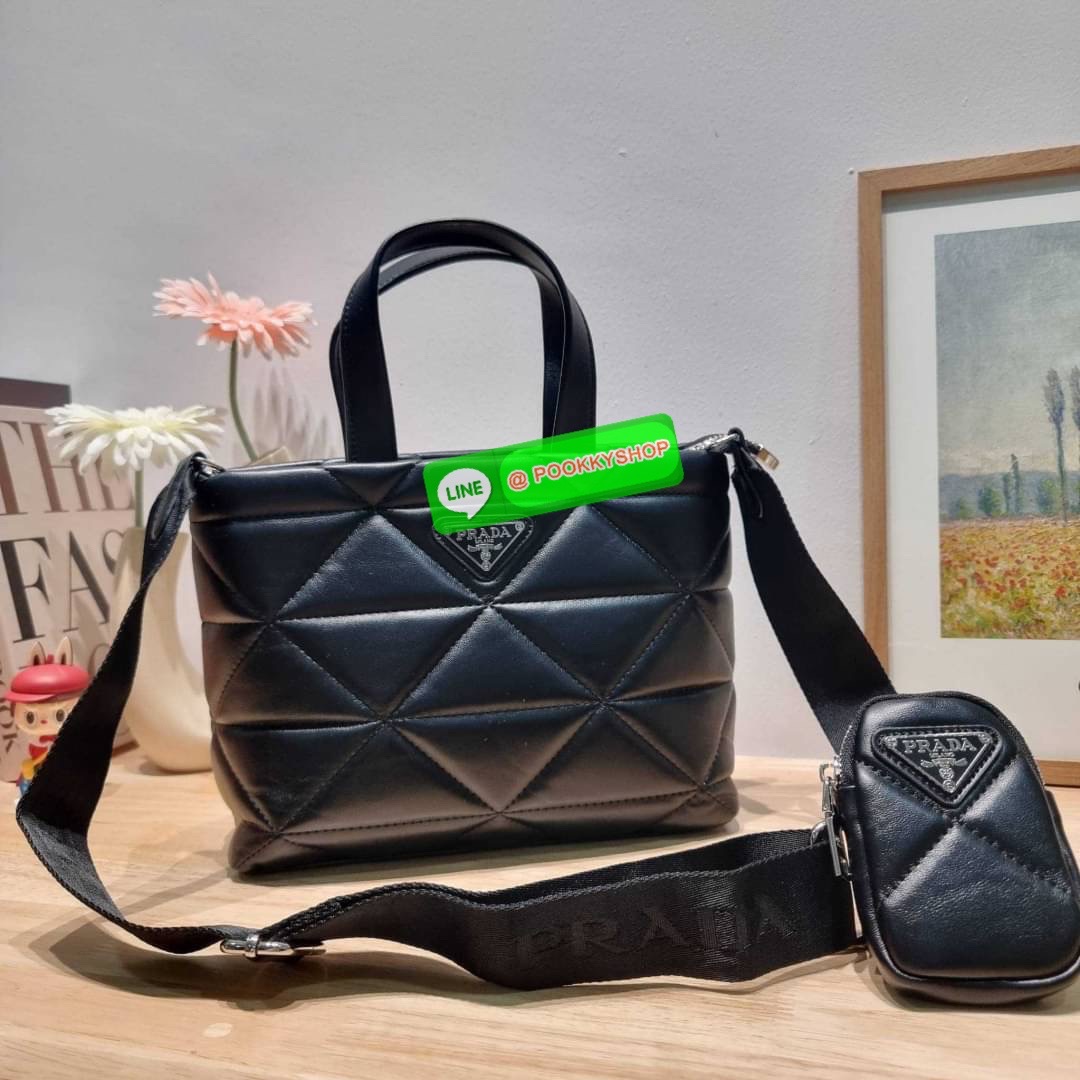 PRADA LEATHER PADDED BAG ใหม่ล่าสุด กับคอลเลคชั่นที่ทำออกมาตอบโจทย์ได้ทุกไลฟ์สไตล์ และเป็นยูนิเซ็กส์ กับกระเป๋าทรงโท้ท ขนาดกำลังดี วัสดุหนังแท้ ตัดเย็บเดินเส้นลายตาราง ปากกระเป๋ามีซิปเปิดปิด ภายในเป็นช่องโล่ง มีช่องแยกให้ มาพร้อมสะพายข้างและใบลูก ให้ได้สน