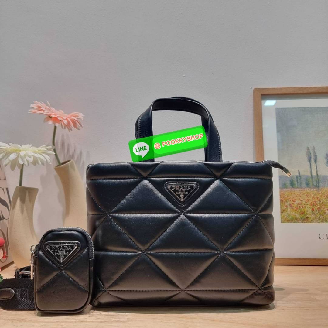 PRADA LEATHER PADDED BAG ใหม่ล่าสุด กับคอลเลคชั่นที่ทำออกมาตอบโจทย์ได้ทุกไลฟ์สไตล์ และเป็นยูนิเซ็กส์ กับกระเป๋าทรงโท้ท ขนาดกำลังดี วัสดุหนังแท้ ตัดเย็บเดินเส้นลายตาราง ปากกระเป๋ามีซิปเปิดปิด ภายในเป็นช่องโล่ง มีช่องแยกให้ มาพร้อมสะพายข้างและใบลูก ให้ได้สน