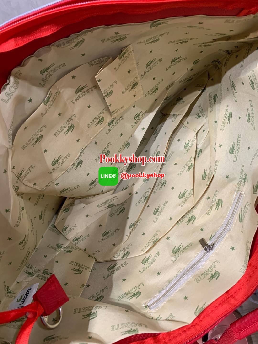 ลาคอส Shopping Bag กระเป๋าถือทรงช้อปปิ้งขนาดใหญ่ ที่ใส่สัมภาระได้รวมถึงใส่เอกสารขนาด A4 ได้ วัสดุ PVC กันน้ำ ดูแลรักษาง่าย ตัดขอบด้วยแถบโลโก้สีเทา ด้านหน้าสกรีนโลโก้และประดับจรเข้อันเป็นสัญลักษณ์ เปิดปิดด้วยซิปเดียว ภายในสกรีนโลโก้แบรนด์ ใบใหญ่สวยโดดเด่