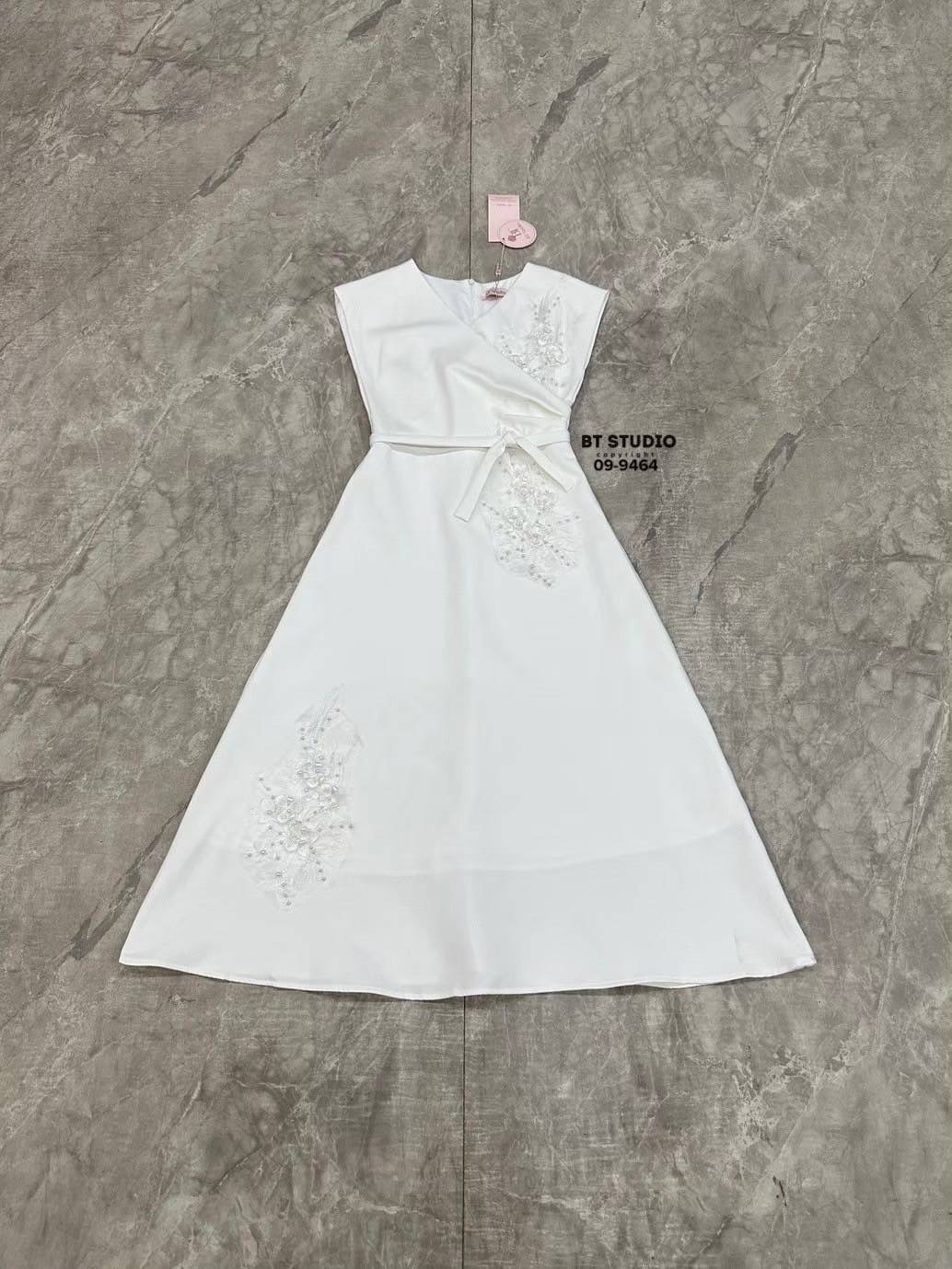 เดรสยาวแขนกุด คอวี ดีไซน์แต่งจับจีบช่วงเอวนึ่งข้าง แต่งปักดอกไม้และมุกด้านหน้าสามจุด ช่วงเอวเข้ารูป ตัวกระโปรงแต่งบานออกเล็กน้อย งานสวยมีซับในซิปหลัง มาพร้อมสายผูกเอว ลุคนี้เรียบหรูดูแพงสุดๆคะ