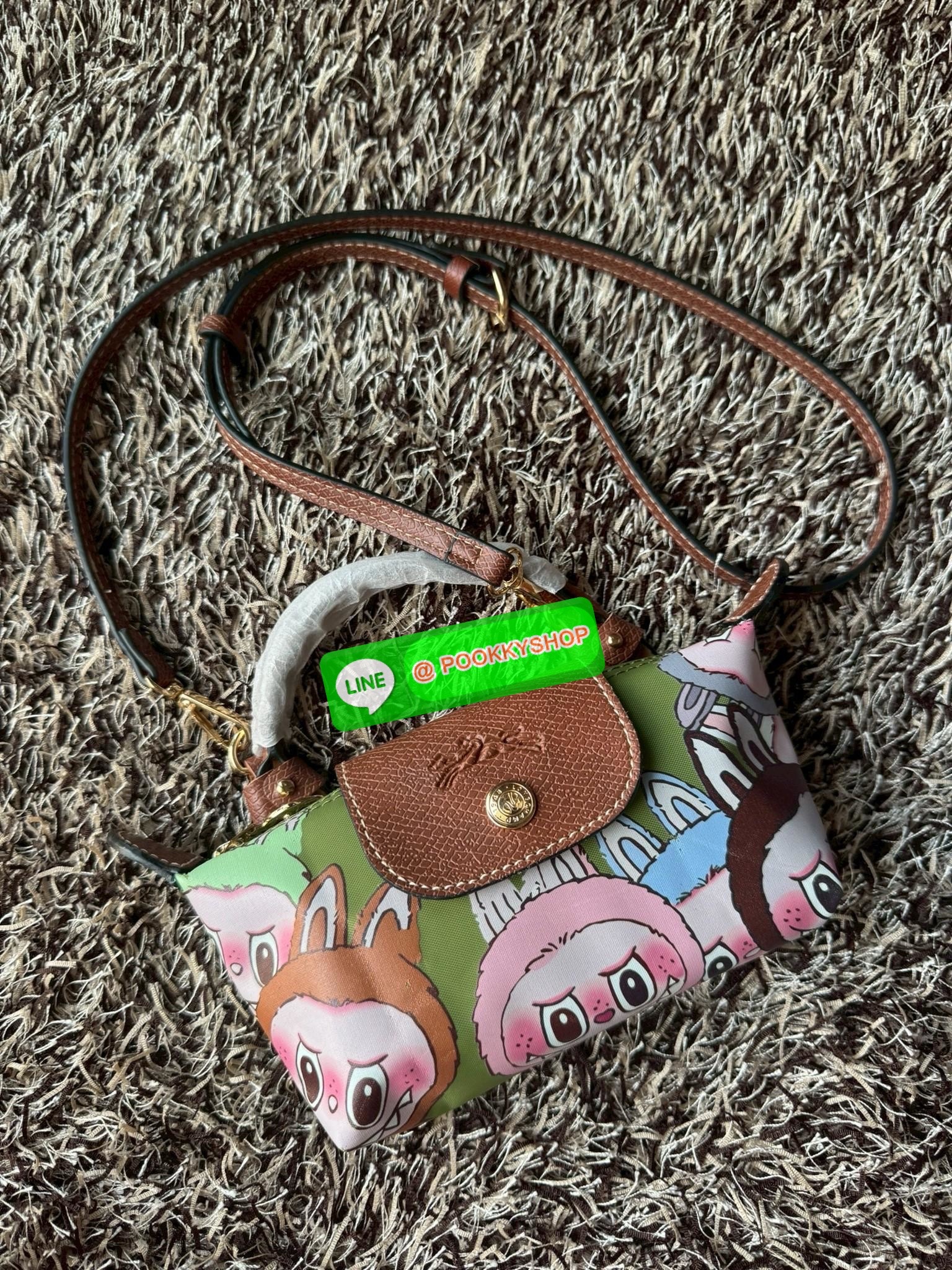 LONGCHAMP LE PLIAGE ORIGINAL X Labubu Pouch with handle เป็นการร่วมงานกัระหว่างแบรนด์ และยังกระเป๋าถือขนาดมินิทรงpouch ที่ด้านหน้ามีลวดลายน้องลาบูบู้ในแบบต่างๆ เปิดปิดระบบสองชั้น ได้ว่าของด้านในมีความปลอดภัย เหมาะอย่างยิ่งสำหรับสาวๆที่ชอบกระเป๋าขนาดมินิไซ