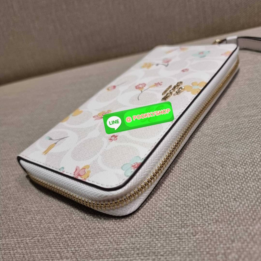 COACH C8695 LONG ZIP AROUND WALLET IN SIGNATURE CANVAS WITH MYSTICAL FLORAL PRINT พร้อมเสิร์ฟความหรู กับคอลใหม่ล่าสุด กระเป๋าสตางค์ใบยาวกึ่งคล้องมือ มาในดีไซน์ผู้ดี เรียบหรู ถือใช้แล้วขับผิวมาก ลวดลายดอกไม้คละเคล้าสวยงาม วัสดุหนังแคนวาสเคลือบลาย มาพร้อมสา
