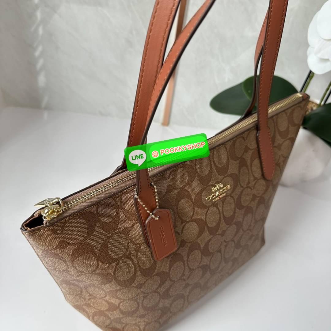 Coach 4455 ZIP TOP TOTE IN SIGNATURE CANVAS กระเป๋าสะพายไหล่ทรง Tote เปิด-ปิดกระเป๋าด้วยซิป ป้องกันของตกหล่น ภายในกว้างใส่สัมภาระได้เยอะ มีช่องเล็กใส่ของจุกจิก วัสดุแคนวาส หูจับหนังแท้ ถือไปเที่ยว ไปทำงาน สะดวกเลยค้า