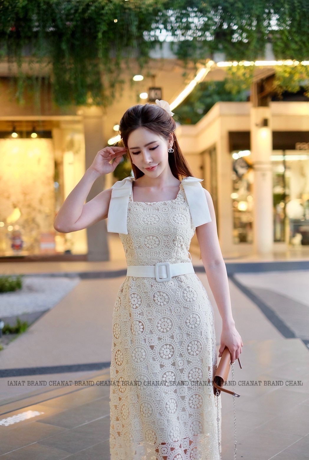 เดรสแฟชั่น เดรสยาวเนื้อผ้าลูกไม้ฉลุวงกลม ดีไซน์แขนกุดตรงบ่าแต่งโบว์ใหญ่สีครีมทั้งสองข้าง