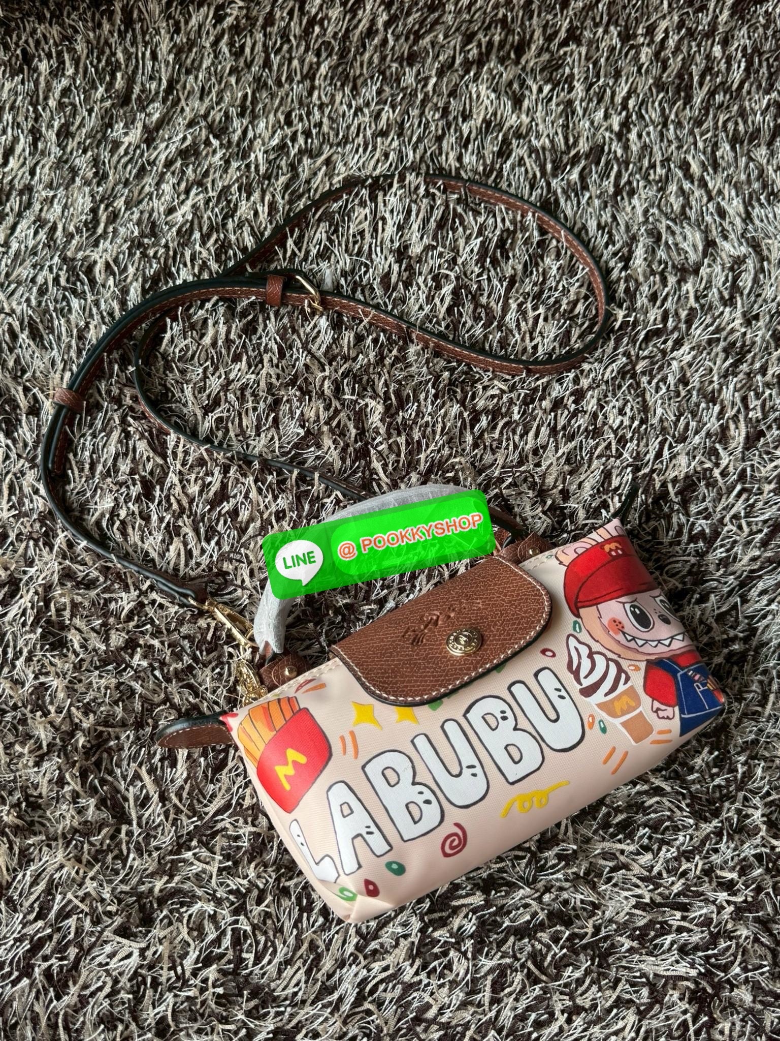 LONGCHAMP LE PLIAGE ORIGINAL X Labubu Pouch with handle เป็นการร่วมงานกัระหว่างแบรนด์ และยังกระเป๋าถือขนาดมินิทรงpouch ที่ด้านหน้ามีลวดลายน้องลาบูบู้ในแบบต่างๆ เปิดปิดระบบสองชั้น ได้ว่าของด้านในมีความปลอดภัย เหมาะอย่างยิ่งสำหรับสาวๆที่ชอบกระเป๋าขนาดมินิไซ