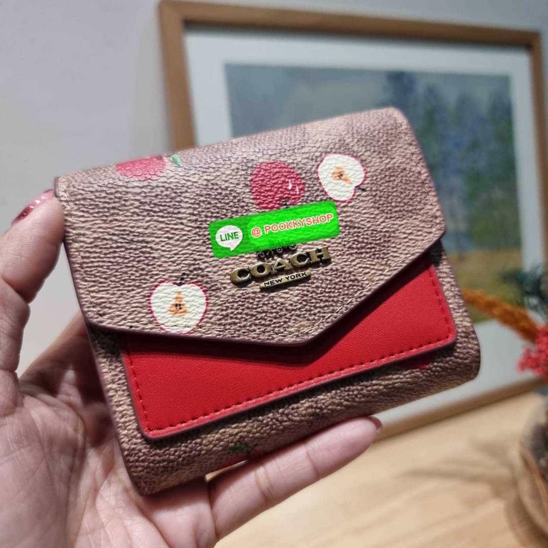 COACH 87709 SMALL WALLET IN SIGNATURE CANVAS WITH SCATTERED APPLE PRINT 🔆 Details กระเป๋าสตางค์ใบสั้น พับสองตอน อะไหล่สีทองเหลือง สวยคลาสสิค แต่งเติมสีสันด้วยแอปเปิ้ลคละเต็มใบ ดูสวยหรูอย่างลงตัว เปิด-ปิดด้วยกระดุม ภายในมีช่องใส่บัตร ใส่ธนบัตรได้ทุ