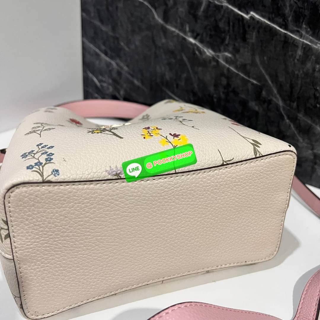 COACH C3598 SMALL TOWN BUCKET WITH SPACED WILDFLOWER PRINT มีความน่ารักละมุนมาก กระเป๋าทรงบัคเก็ต ดีไซน์ดอกไม้คละรอบใบ วัสดุหนังแท้ปากกระเป๋าเปิด-ปิดด้วยกระดุมแม่เหล็ก 2 มีหูจับในตัวและสายสะพายข้าง ภายในโล่งกว้าง มีช่องซิปแยกสัดส่วนตรงกลาง สายสะพายปรับระด