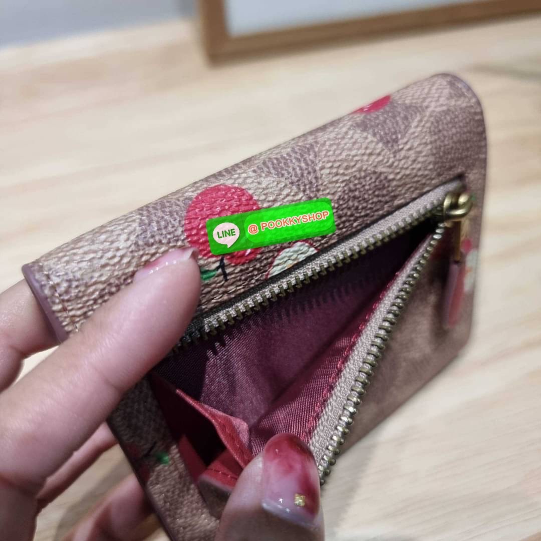 COACH 87709 SMALL WALLET IN SIGNATURE CANVAS WITH SCATTERED APPLE PRINT 🔆 Details กระเป๋าสตางค์ใบสั้น พับสองตอน อะไหล่สีทองเหลือง สวยคลาสสิค แต่งเติมสีสันด้วยแอปเปิ้ลคละเต็มใบ ดูสวยหรูอย่างลงตัว เปิด-ปิดด้วยกระดุม ภายในมีช่องใส่บัตร ใส่ธนบัตรได้ทุ