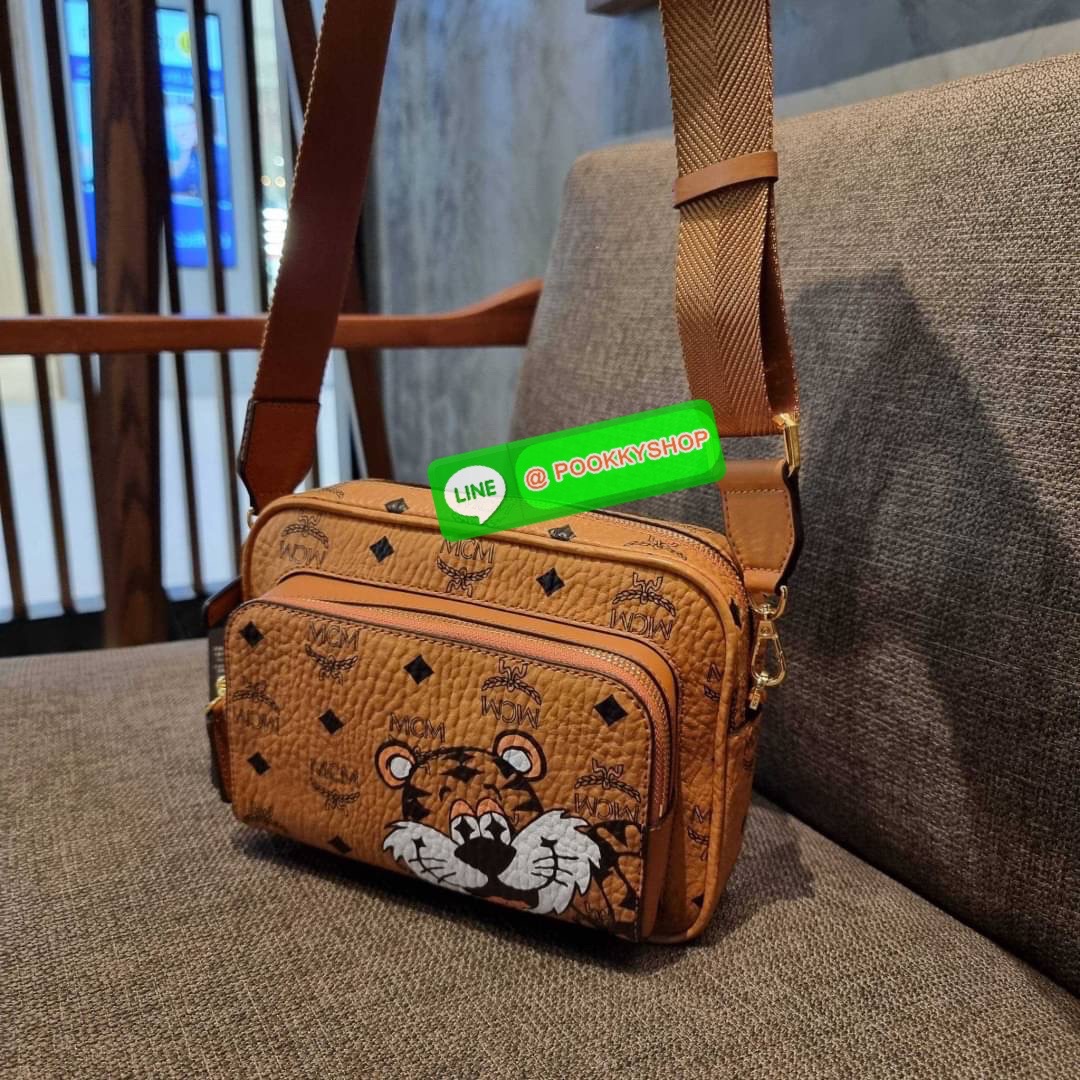 MCM KLASSIK CROSSBODY IN NEW YEAR TIGER VISETOS ใหม่ล่าสุด คอลเลคชั่นรับปีเสือ ของมันต้องมี กระเป๋าสะพายข้างทรงครอสบอดี้ โดดเด่นด้วยลายพริ้นท์น้องเสือคมสวย รุ่นนี้หนุ่มๆหรือสาวๆก็สะพายได้น้า ขนาดกำลังดี วัสดุหนังแคนวาสคุณภาพดี มีช่องหลัก 2 ช่อง เปิด-ปิดด้