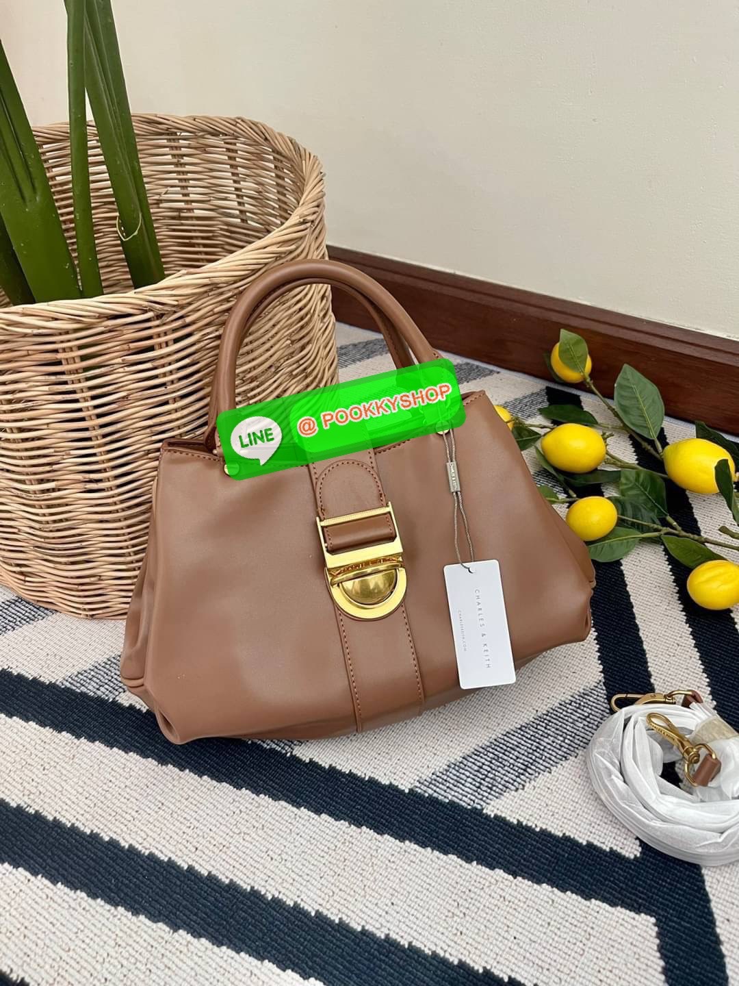 Charles & Keith Buckled Tote Bag กระเป๋าถือทรงเก๋สะดุดตาตกแต่งสายคาดพร้อมหัวเข็มขัดให้กระเป๋าดูโดดเด่นทันสมัย วัสดุหนังเรียบ หูหิ้วกระเป๋าสามารถพับได้ เปิดปิดแบบตัวเข็มขัดด้านหน้า ด้านในกว้าง พกพาของใช้จำเป็นได้อย่างครบถ้วน เช่น กระเป๋าเงินใบยาว โทรศัพท์
