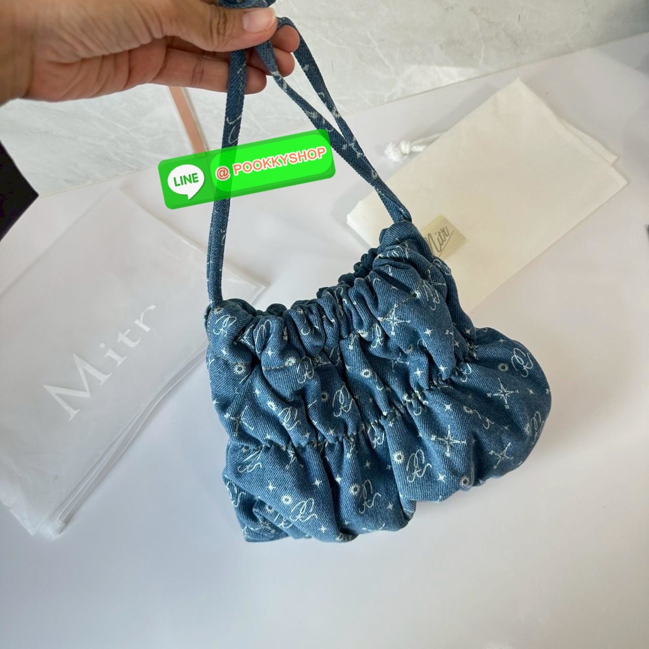 Mitr scrunchy bag 🔖กระเป๋ายีนส์สุดน่ารักเนื้อนุ่มพิมพ์ลาย Monogram ของ Mitr จุของได้เยอะรูปทรงแบบรูดได้ น้ำหนักเบาสุดๆ สะพายเป็น Shoulder Bag หรือถอดสายและถือเป็น Clutch Bag ก็ได้ ดีเทล Charm ห้อยโลหะสีเงิน โดดเด่นสุดๆ