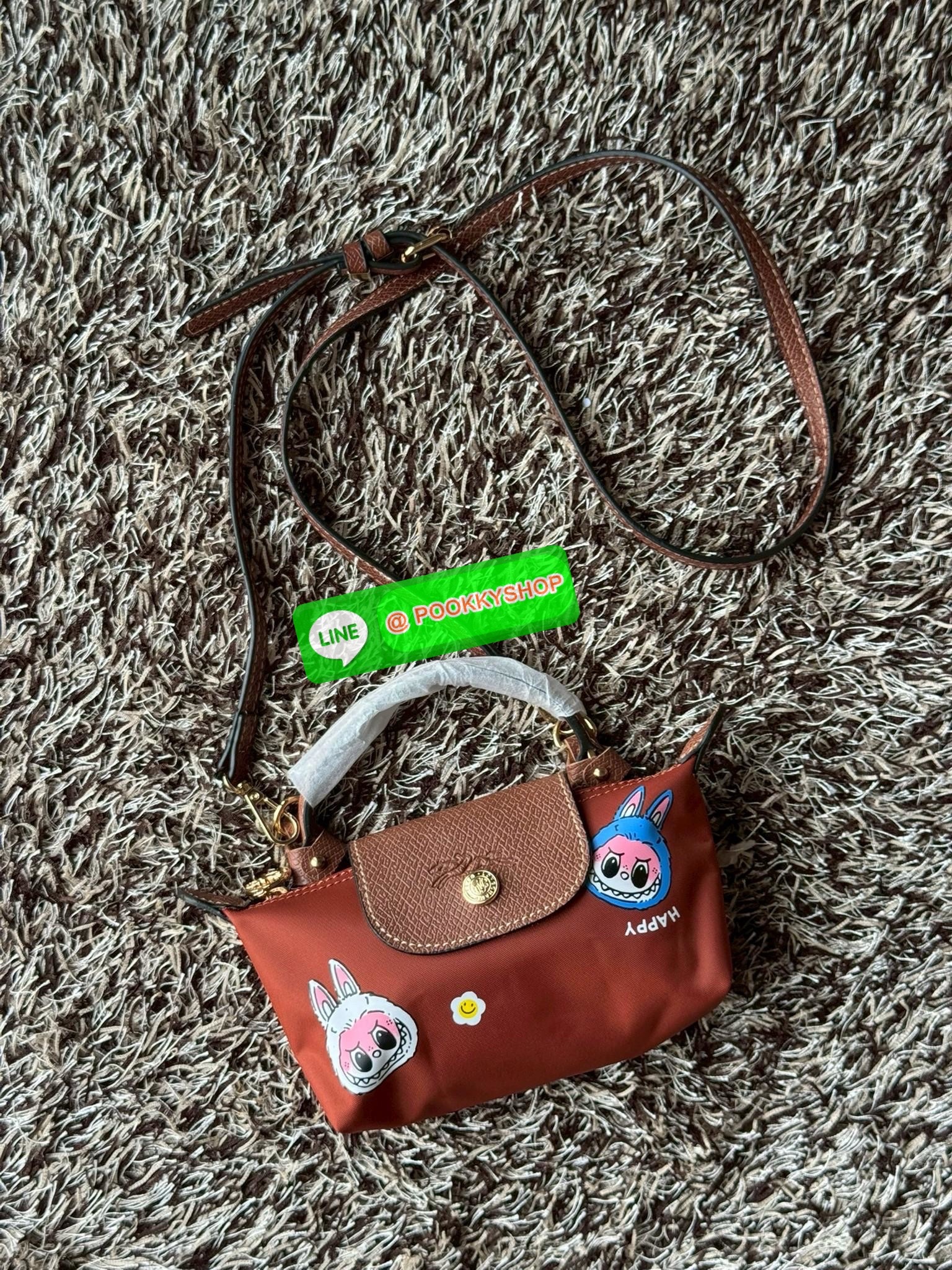 LONGCHAMP LE PLIAGE ORIGINAL X Labubu Pouch with handle เป็นการร่วมงานกัระหว่างแบรนด์ และยังกระเป๋าถือขนาดมินิทรงpouch ที่ด้านหน้ามีลวดลายน้องลาบูบู้ในแบบต่างๆ เปิดปิดระบบสองชั้น ได้ว่าของด้านในมีความปลอดภัย เหมาะอย่างยิ่งสำหรับสาวๆที่ชอบกระเป๋าขนาดมินิไซ