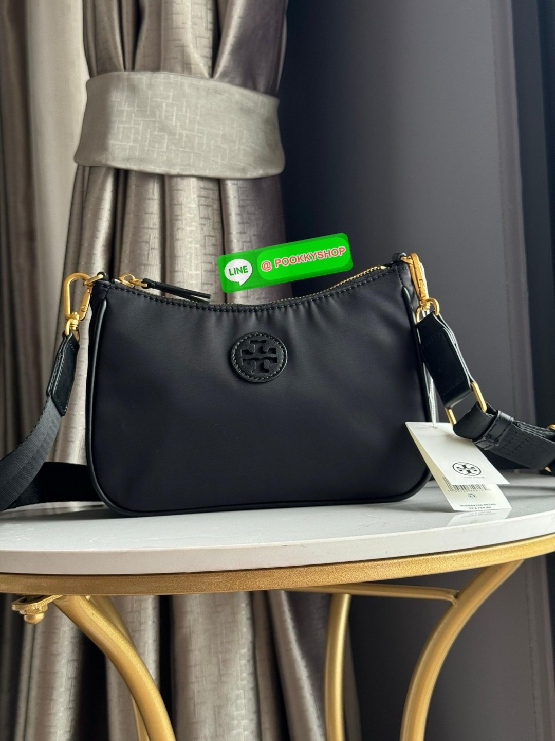 Tory burch nylon web mini hobo เป็นอีกหนึ่งตัวเลือกที่น่าสนใจสำหรับคนที่กำลังมองหากระเป๋าที่เน้นการใช้งาน ดีไซน์เรียบง่าย น้ำหนักเบา เน้นการใช้งานเป็นหลัก อีกทั้งยังมีสายสะพายแบบสปอร์ตช่วยคุณสะพายบนไหล่หรือครอสบอดี้ได้สะดวก ที่สำคัญ ผลิตจากผ้าไนลอนที่มีคว