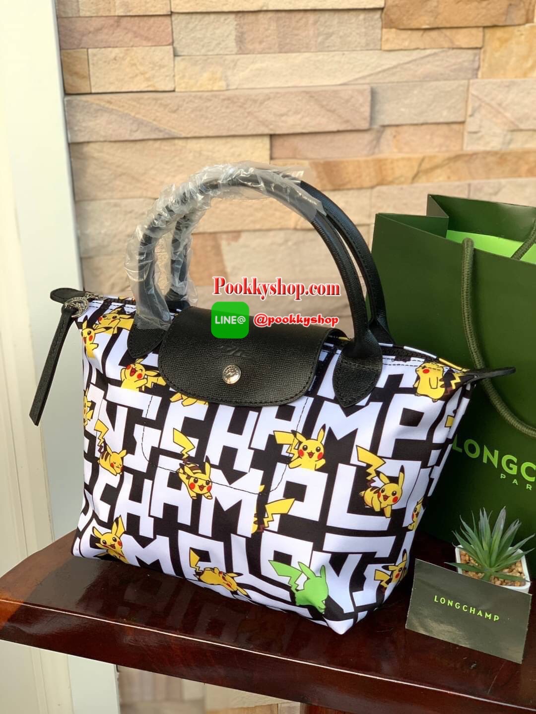 LONGCHAMP X POKÉMON SHOULDER BAG เพราะรู้ว่า &quot;เลอ ปลิยาจ&quot; (Le Pliage) เป็นกระเป๋าไอคอนิคยอดนิยมของคนทุกเพศทุกวัย ไม่ว่าจะเป็นคนธรรมดาหรือเซเล็บ ลองฌอมป์ก็เลยจัดให้ &quot;ปิกาจู&quot; ไปวิ่งเล่นอยู่บนกระเป๋าที่ออกมาเป็นซีรีส์ซะเลย และยังคงความ Le