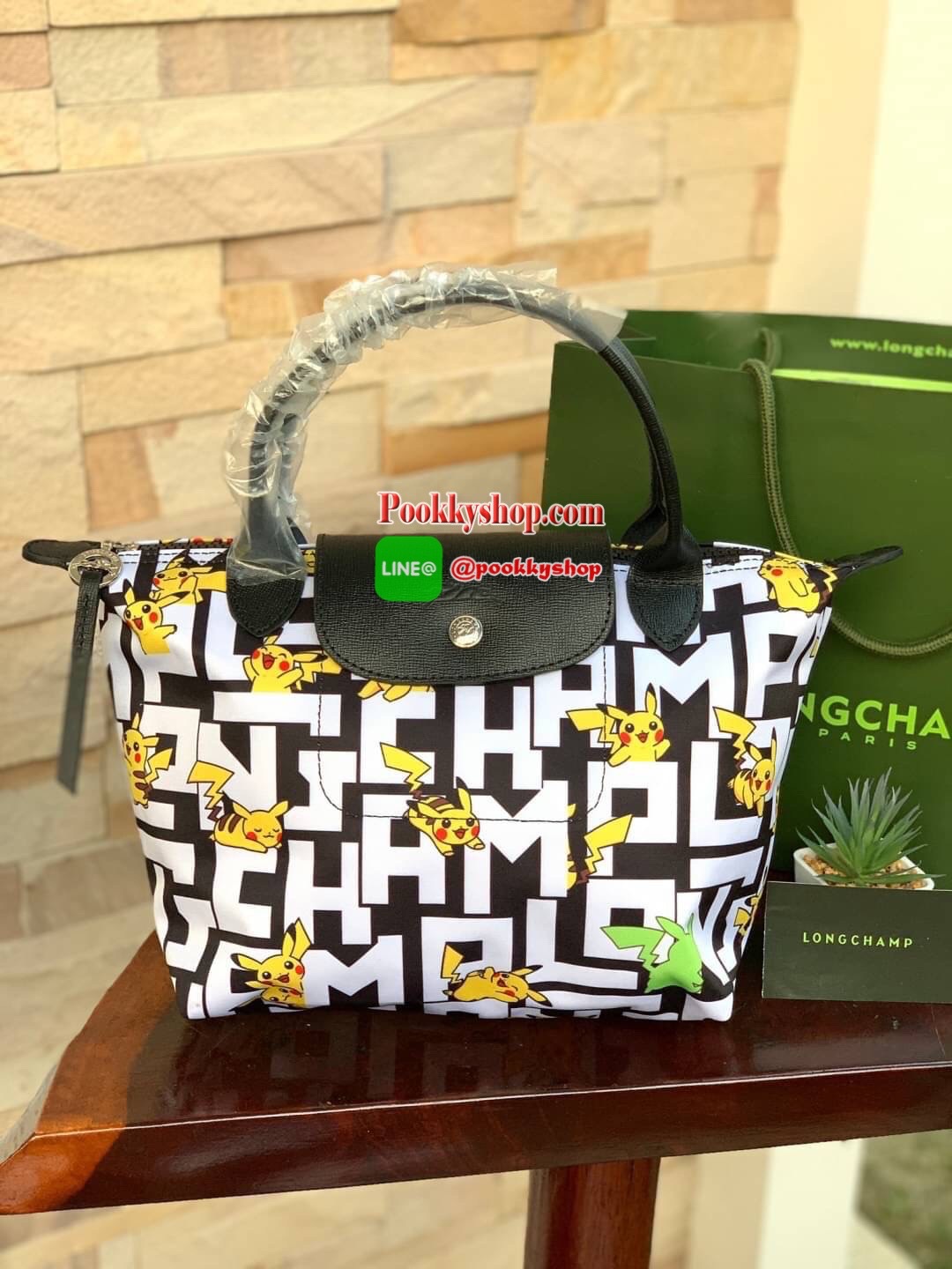 LONGCHAMP X POKÉMON SHOULDER BAG เพราะรู้ว่า &quot;เลอ ปลิยาจ&quot; (Le Pliage) เป็นกระเป๋าไอคอนิคยอดนิยมของคนทุกเพศทุกวัย ไม่ว่าจะเป็นคนธรรมดาหรือเซเล็บ ลองฌอมป์ก็เลยจัดให้ &quot;ปิกาจู&quot; ไปวิ่งเล่นอยู่บนกระเป๋าที่ออกมาเป็นซีรีส์ซะเลย และยังคงความ Le