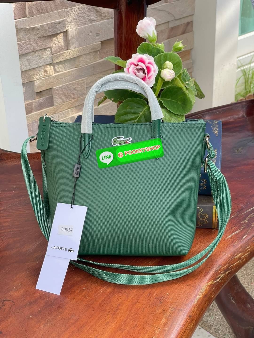 ลาคอส Women's L.12.12 Concept Petit Piqué Zip Tote กระเป๋าสะพายข้างทรง mini tote วัสดุ pvc100% เปิดปิดด้วยซิปเดียวด้านบนสะดวกใช้งาน ใส่มือถือได้ทุกรุ่น ด้านหน้ามีดีเทลโลโก้ปักดูโดดเด่น สายของกระเป๋ารุ่นนี้สามารถปรับความยาวได้ฟรีไซส์ เลือกสะพายได้ ไ