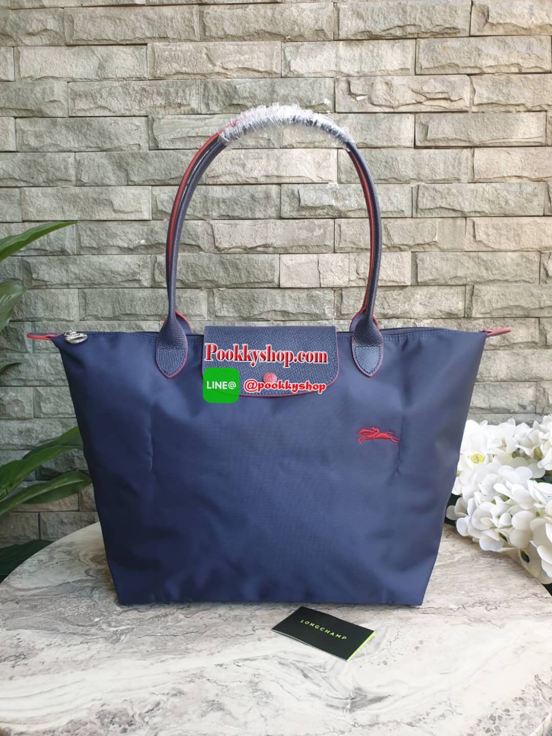 Longchamp Le Pliage Club Tote Bag Size L หูยาว วัสดุเนื้อผ้า Nylon Canvas เคลือบกันนำ้ ตัดด้วยหนังแท้ที่มีน้ำหนักเบา ดีไซน์เรียบง่ายแต่เต็มไปด้วยความคลาสสิก จนเป็นที่ชื่นชอบไปทั่วโลก Longchamp ปรับโฉม LE PLIAGE ด้วยการปักลายรูปม้า-ตราสัญลักษณ์ของแบรนด์บนผ