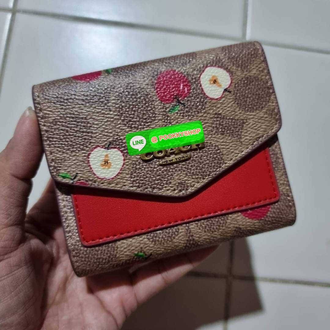 COACH 87709 SMALL WALLET IN SIGNATURE CANVAS WITH SCATTERED APPLE PRINT 🔆 Details กระเป๋าสตางค์ใบสั้น พับสองตอน อะไหล่สีทองเหลือง สวยคลาสสิค แต่งเติมสีสันด้วยแอปเปิ้ลคละเต็มใบ ดูสวยหรูอย่างลงตัว เปิด-ปิดด้วยกระดุม ภายในมีช่องใส่บัตร ใส่ธนบัตรได้ทุ