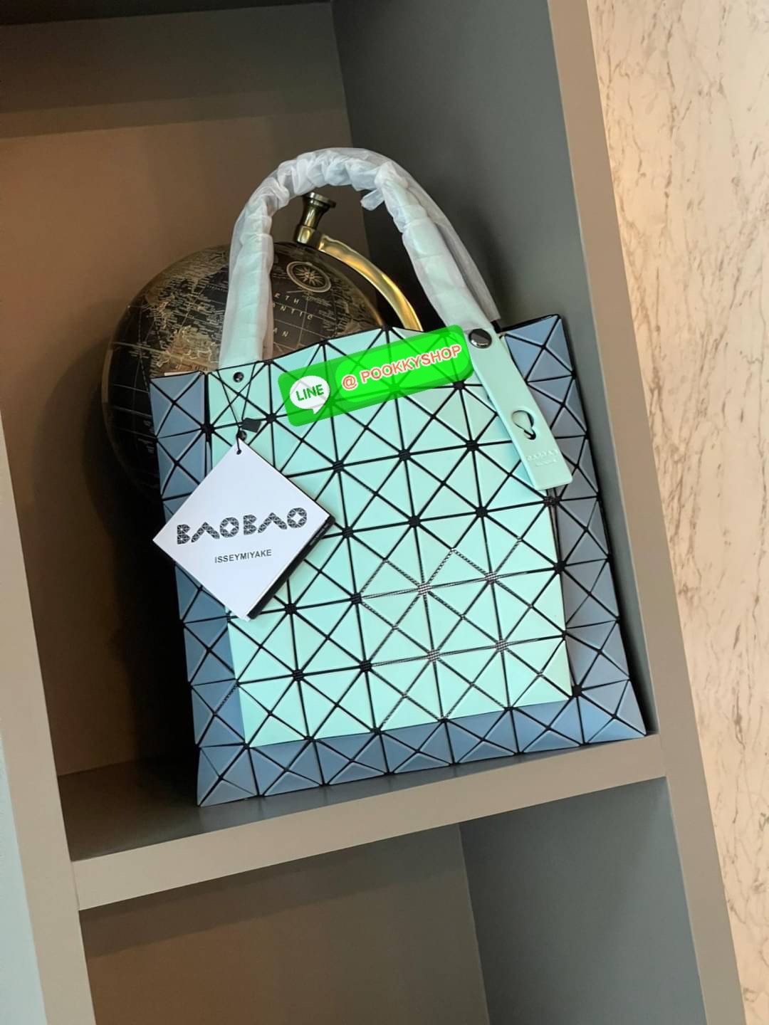 Baobao Issey Miyake Prism Kangaroo tote bag กระเป๋าถือทรงโท้ทที่ประดิษฐ์ขึ้นอย่างเชี่ยวชาญในญี่ปุ่น มาพร้อมแผงเรขาคณิตสำหรับการออกแบบที่ได้รับแรงบันดาลใจจากกระดาษพับ ซิลลูเอทอันเป็นเอกลักษณ์นี้ปิดท้ายด้วยสายรัดแบบอสมมาตร มีการพัฒนาโครงสร้างทรงสามเหลี่ยมเพ