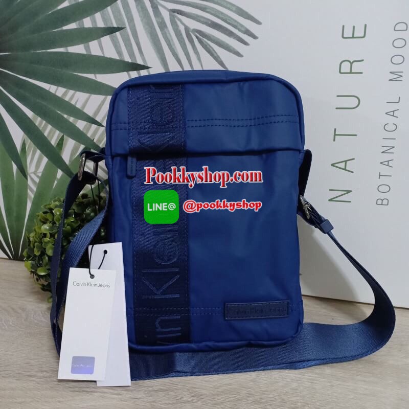 Calvin Klein Jeans กระเป๋าสะพายหนังเรียบด้าน หนังกันน้ำ สะพายได้สองแบบ crossbody และสามารถปรับเป็นสายคู่สะพายข้างได้ ขนาดกำลังดีไม่เล็กไม่ใหญ่จนเกินไป พกพาสะดวก ด้านหน้าประดับด้วยป้ายโลโก้แบรนด์ มีช่องซิป1ช่อง กระเป๋าเปิดปิดด้วยซิปบน หัวซิปโลโก้แบรนด์ ภาย