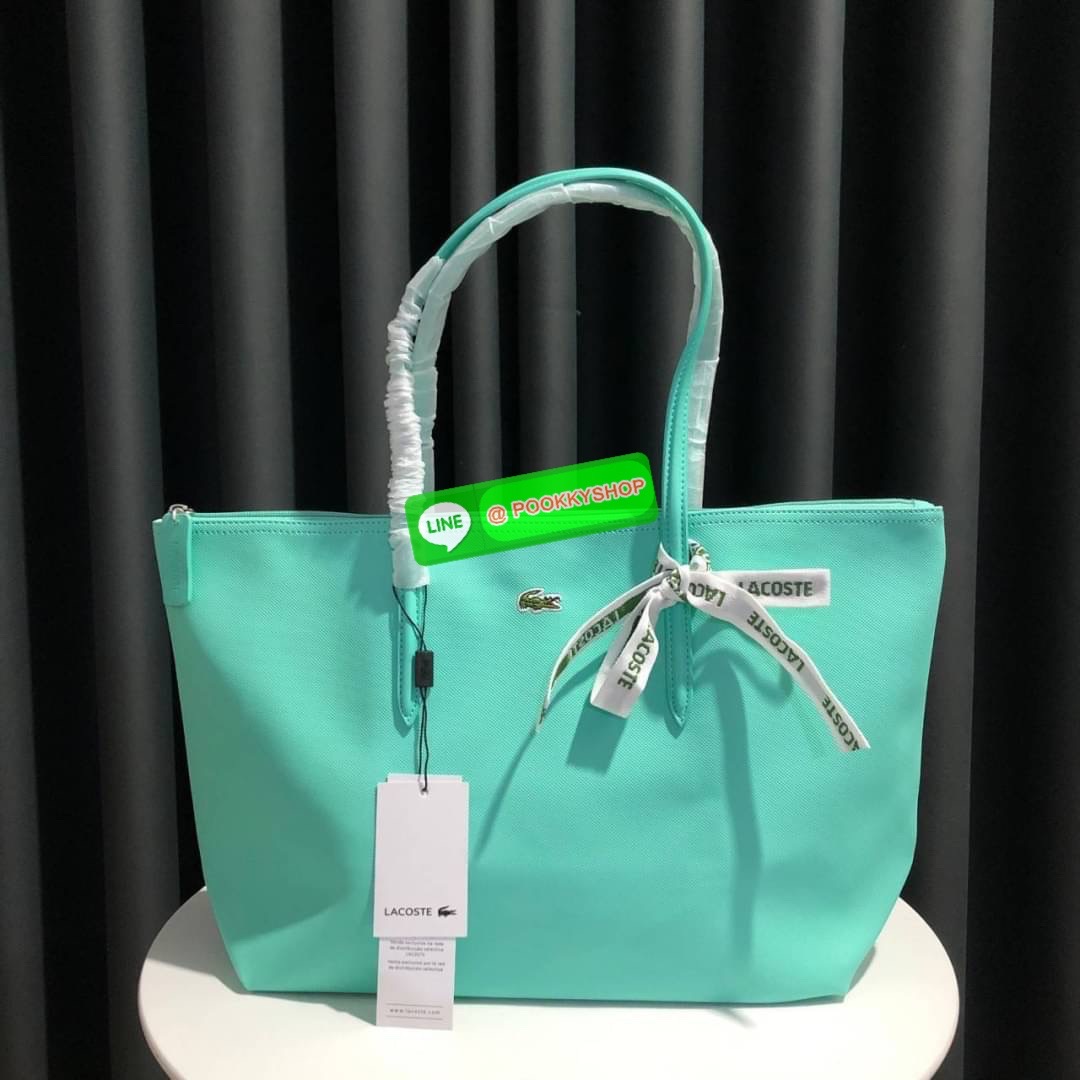 ลาคอส Classic Tote Bag กระเป๋าสะพายทรงช้อปปิ้งหลากสีรุ่นยอดนิยมด้านหน้าประดับโลโก้จระเข้สัญลักษณ์แบรนด์ ภายในกว้างจุได้เยอะ เปิดปิดด้วยซิปสะดวกใช้ มี1 ช่องซิปเล็ก หัวซิปปั้มเเบรนด์ วัสดุกันน้ำ ขนาดกำลังดี ใส่หนังสือ เอกสารA4 ของใช้ได้เยอะ สวยทุกสีค่ะ