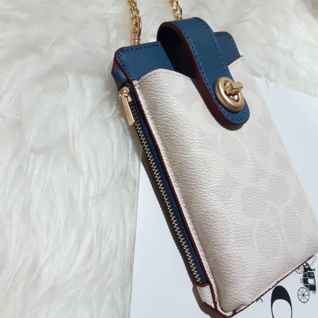 COACH 825 TURNLOCK CHAIN PHONE CROSSBODY IN BLOCKED SIGNATURE CANVAS ฮอตและปังกว่านี้ไม่มีแล้ว!! กระเป๋าเอนกประสงค์ สำหรับใส่โทรศัพท์ ใส่บัตรได้ มีช่องซิปแยกให้ด้วย ขนาดพกพาดีงาม!! 💕 ใส่โทรศัพท์ได้ทุกรุ่นน้า สายสะพายยาวประมาณ 23" (วัดจากไหล่)