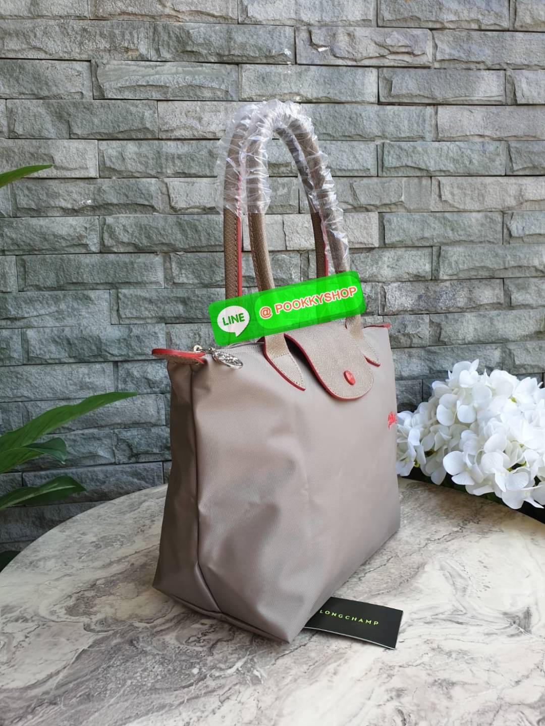 Longchamp Le Pliage Club Tote Bag Size S หูยาว วัสดุเนื้อผ้า Nylon Canvas เคลือบกันนำ้ ตัดด้วยหนังแท้ที่มีน้ำหนักเบา ดีไซน์เรียบง่ายแต่เต็มไปด้วยความคลาสสิก จนเป็นที่ชื่นชอบไปทั่วโลก Longchamp ปรับโฉม LE PLIAGE ด้วยการปักลายรูปม้า-ตราสัญลักษณ์ของแบรนด์บนผ