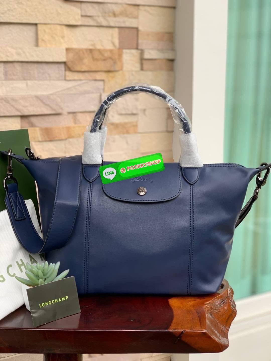 Longchamp LE PLIAGE CUIR TOP HANDLE BAG S เรียกว่าเป็นกระเป๋าอีกหนึ่งรุ่นที่ไม่ว่ายังไงก็ฮอตฮิตและติดเทรนด์ตลอดไม่เคยเปลี่ยนกับ ทรง Le Pliage Cuir หนึ่งในตระกูลกระเป๋าสุดไอคอนิกจากแบรนด์ เมื่อรุ่น Le Pliage Cuir ในรูปแบบของหนังแกะ Metis ได้ถือกำเนิดขึ้นใน