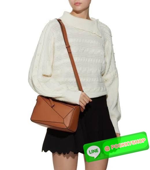 Loewe Puzzle Bag In Classic กระเป๋าทรง Puzzle นี้ออกแบบโดย Jonathan Anderson โดยได้รับแรงบันดาลใจในการออกแบบมาจากรูปทรงของลูกรักบี้ ดังนั้น จึงจะเห็นได้ว่าการตัดเย็บและรูปทรงของกระเป๋านั้นคล้ายคลึงกับลูกรักบี้ รูปทรงดูมินิมอลไม่ทิ้งคอนเซ็ปต์ของแบรนด์ สามา