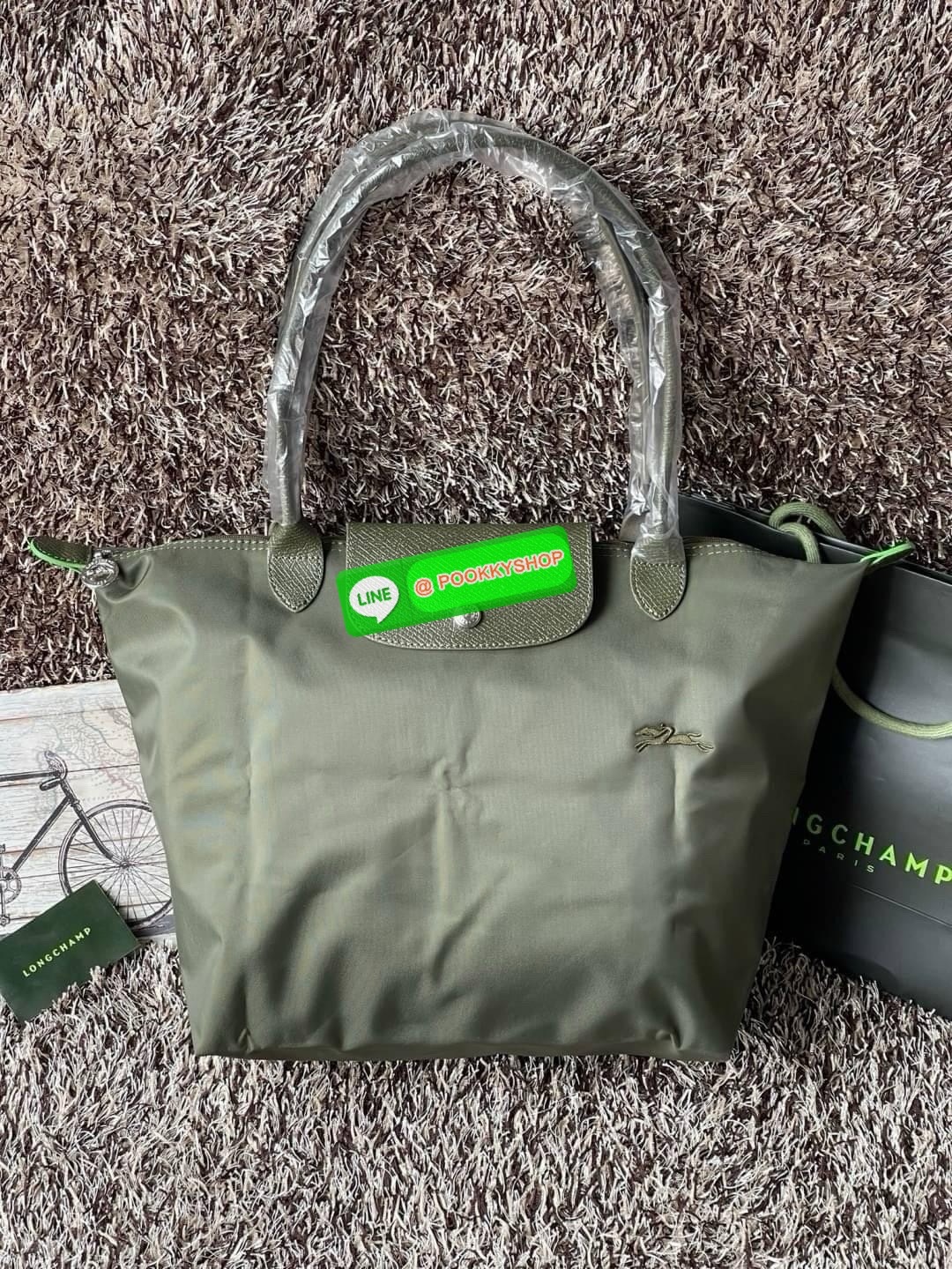 LONGCHAMP LE PLIAGE GREEN Shoulder bag L กระเป๋าโท้ทใบนี้ดึงดูดใจคุณด้วยรูปทรงมินิมอลและปริมาตรที่เพียงพอซึ่งสามารถเก็บเอกสารหรือแล็ปท็อปทั้งหมดของคุณได้อย่างง่ายดาย ด้ามยาวช่วยให้คุณสวมใส่ได้อย่างสบายบนไหล่ ขณะที่การปิดด้วยซิปช่วยให้มั่นใจได้ว่าสิ่งของทั