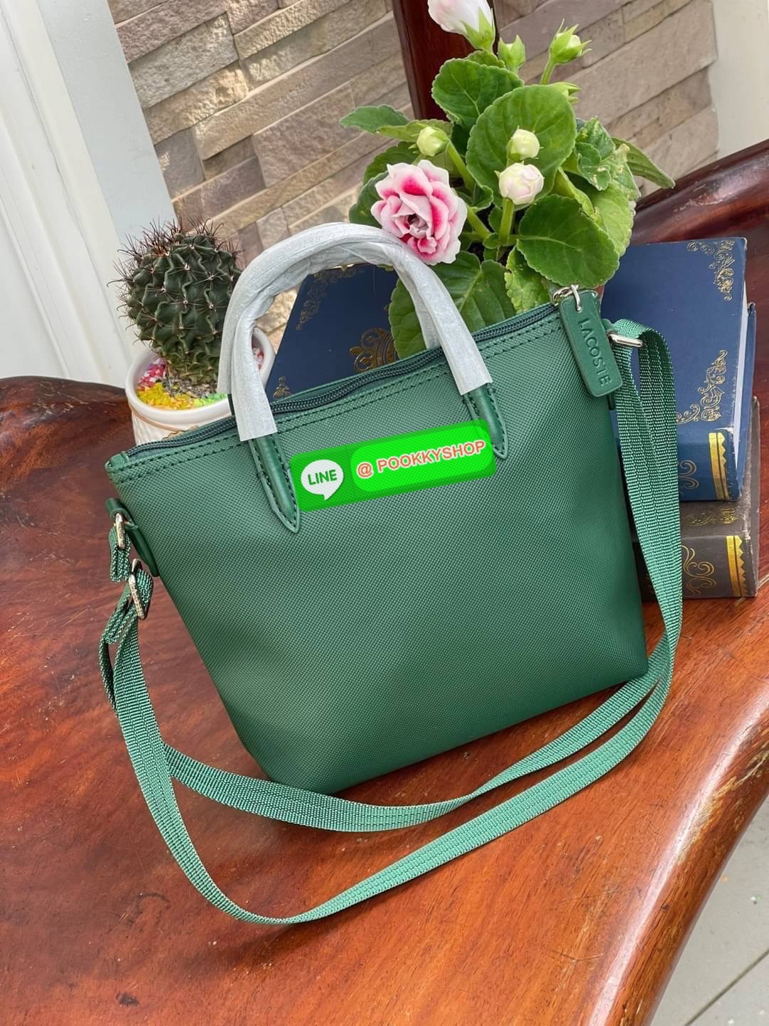 ลาคอส Women's L.12.12 Concept Petit Piqué Zip Tote กระเป๋าสะพายข้างทรง mini tote วัสดุ pvc100% เปิดปิดด้วยซิปเดียวด้านบนสะดวกใช้งาน ใส่มือถือได้ทุกรุ่น ด้านหน้ามีดีเทลโลโก้ปักดูโดดเด่น สายของกระเป๋ารุ่นนี้สามารถปรับความยาวได้ฟรีไซส์ เลือกสะพายได้ ไ