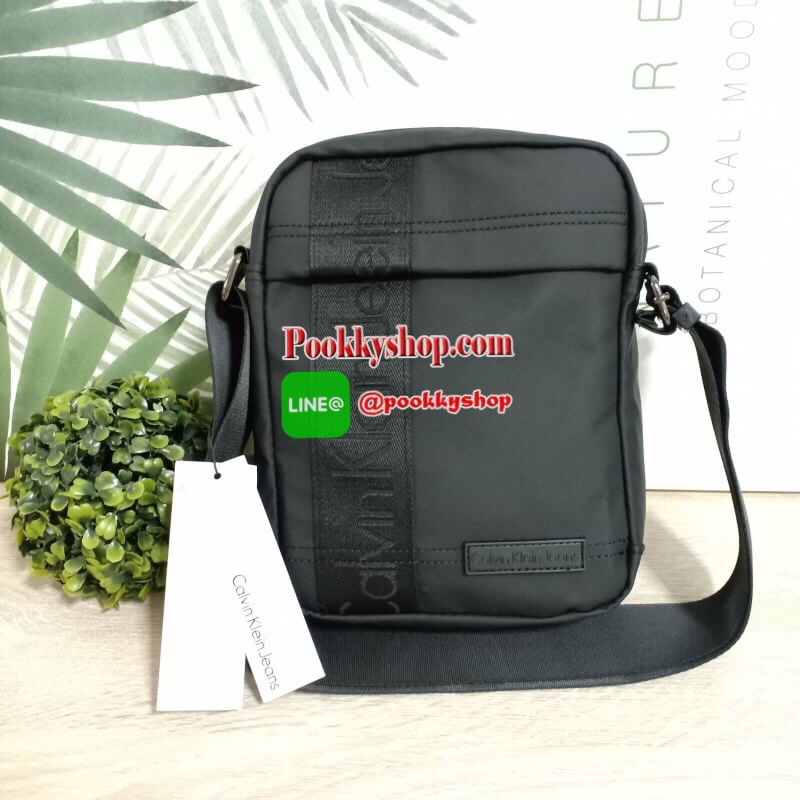 Calvin Klein Jeans กระเป๋าสะพายหนังเรียบด้าน หนังกันน้ำ สะพายได้สองแบบ crossbody และสามารถปรับเป็นสายคู่สะพายข้างได้ ขนาดกำลังดีไม่เล็กไม่ใหญ่จนเกินไป พกพาสะดวก ด้านหน้าประดับด้วยป้ายโลโก้แบรนด์ มีช่องซิป1ช่อง กระเป๋าเปิดปิดด้วยซิปบน หัวซิปโลโก้แบรนด์ ภาย