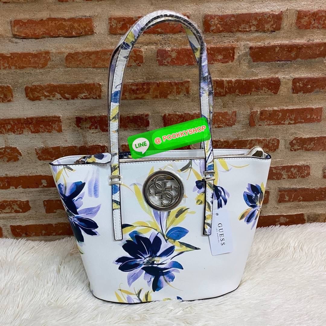 GUESS OPEN ROAD FLORAL TOTE BAG กระเป๋าถือขนาดกลางทรงสวย ฐานตั้งอยู่ทรง สะพายไหล่ได้ วัสดุหนังซาฟิโน่แต่งลายดอกไม้สดใส ด้านหน้าติดโลโก้ลายฉลุสีทองทรงกลมเพิ่มความหรูหรา เปิดปิดด้วยซิปเป็นหลัก ด้านในมีช่องซิป ใส่กระเป๋าสตางค์ มือถือ นิตยสาร ของใช้จุกจิกได้เ