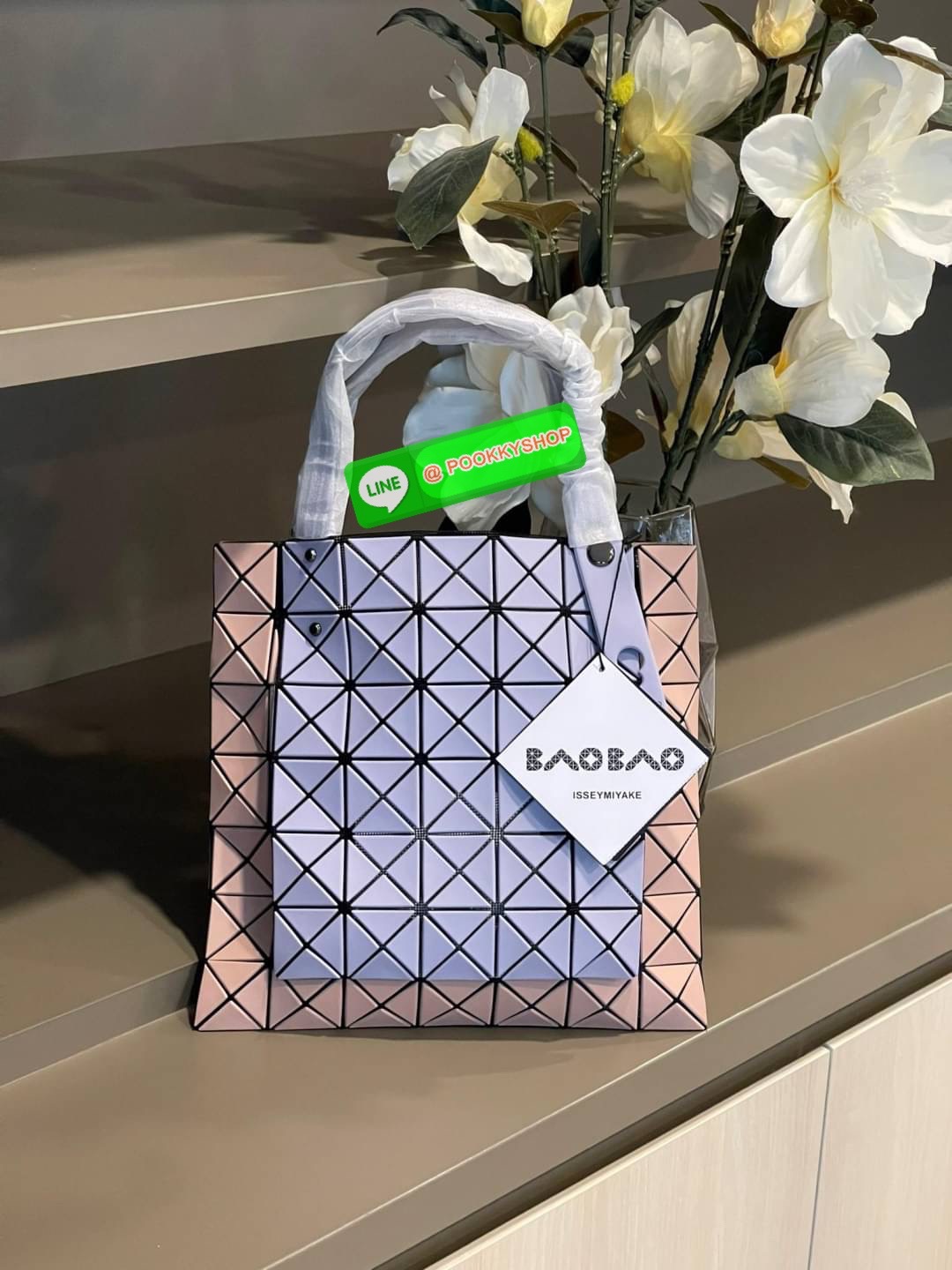 Baobao Issey Miyake Prism Kangaroo tote bag กระเป๋าถือทรงโท้ทที่ประดิษฐ์ขึ้นอย่างเชี่ยวชาญในญี่ปุ่น มาพร้อมแผงเรขาคณิตสำหรับการออกแบบที่ได้รับแรงบันดาลใจจากกระดาษพับ ซิลลูเอทอันเป็นเอกลักษณ์นี้ปิดท้ายด้วยสายรัดแบบอสมมาตร มีการพัฒนาโครงสร้างทรงสามเหลี่ยมเพ